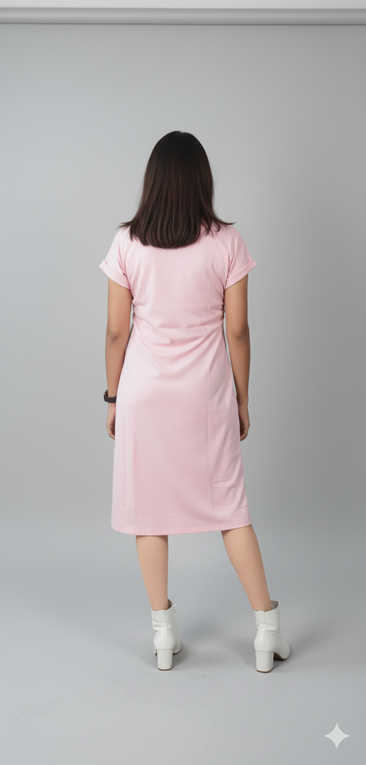 Person wearing a pink dress standing against a gray background