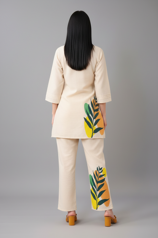 Person wearing a beige outfit with leaf patterns on a gray background