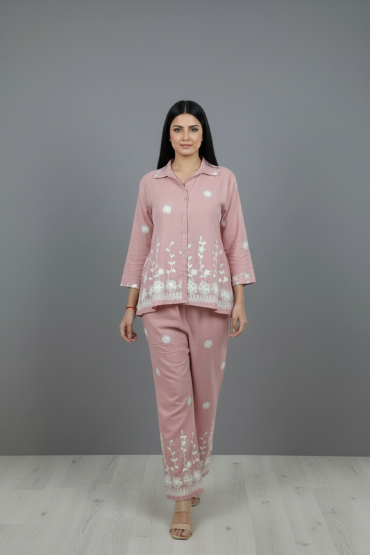 Woman wearing a pink outfit with white patterns on a gray background