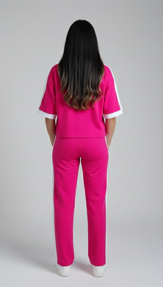 Woman wearing hot pink Miss Dior co-ord set with oversized t-shirt and straight-fit pants styled with white sneakers.