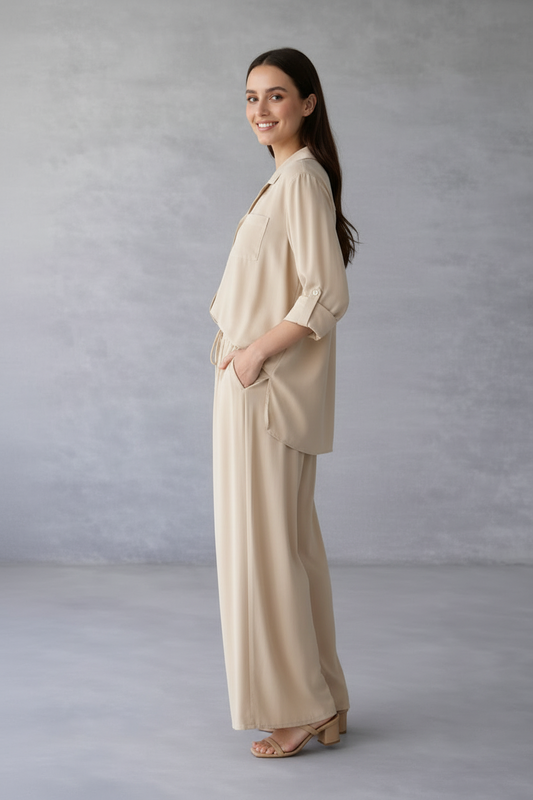 Woman wearing a beige outfit against a gray background