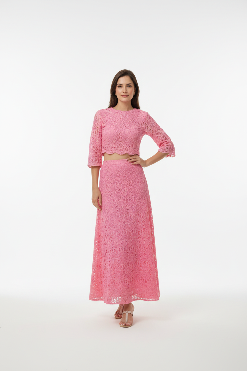 Woman wearing a pink embroidered outfit on a white background