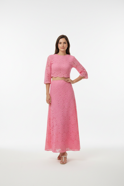 Woman wearing a pink embroidered outfit on a white background