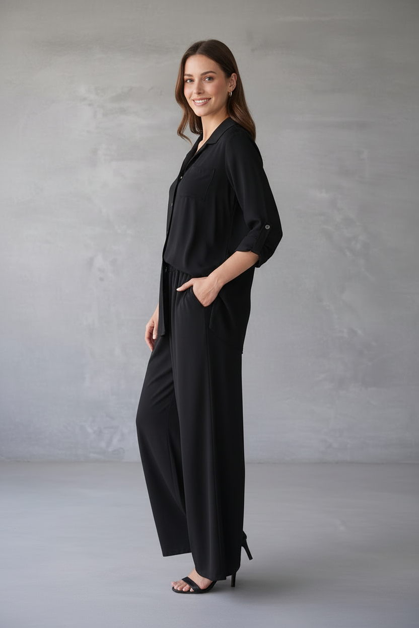 Woman wearing a black outfit against a gray background