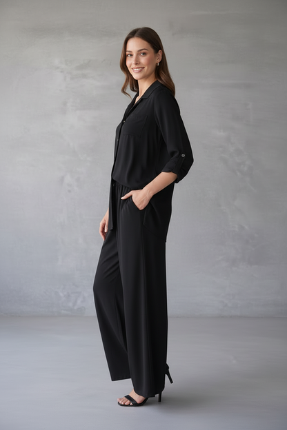 Woman wearing a black outfit against a gray background