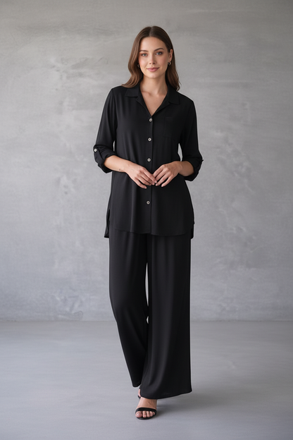 Woman wearing a black outfit against a gray background