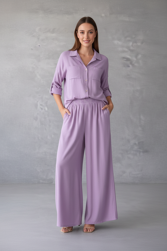 Woman wearing a lavender outfit against a gray background
