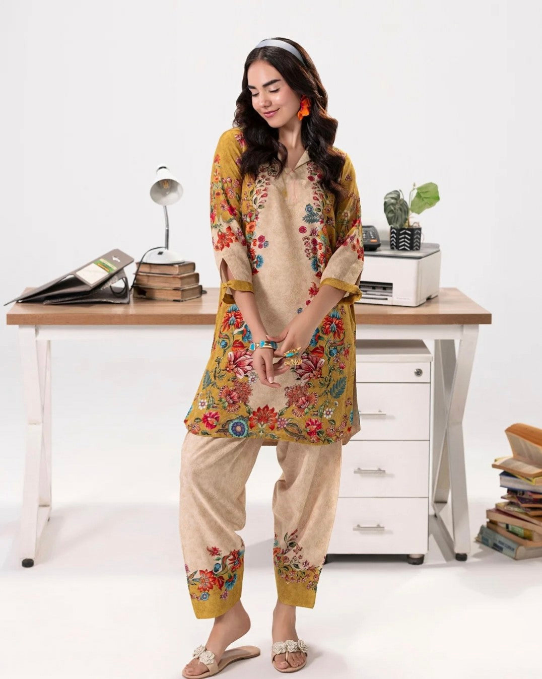 “Model sitting on office desk wearing NXG16 minimal floral co-ord set, a chic blend of workwear comfort and festive wedding season vibes.”