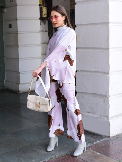Woman in a stylish outfit with a white handbag standing against a building.