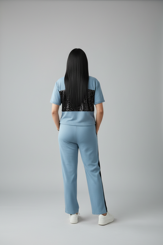 Person wearing a light blue outfit with black accents on a gray background