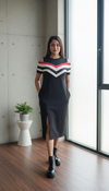 Woman wearing a black cotton chevron stripe cold-shoulder midi dress with side pockets and front slit
