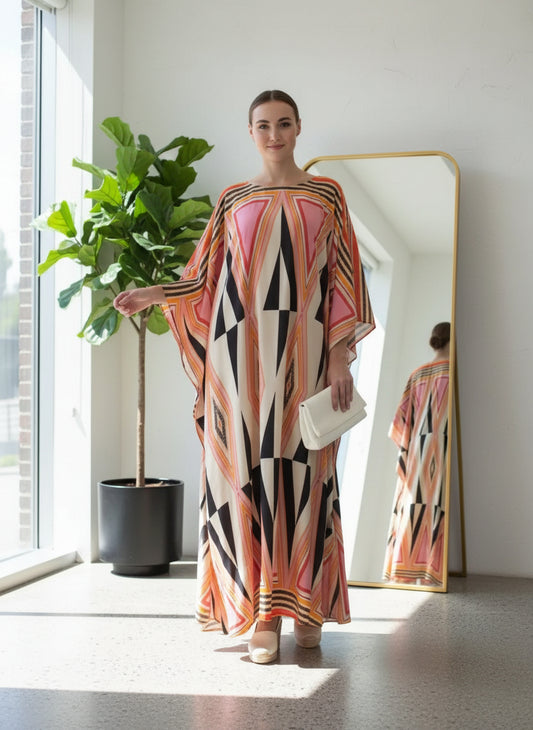 Woman wearing a long geometric printed kaftan in pink, black, and beige tones crafted from smooth Korean BSY fabric