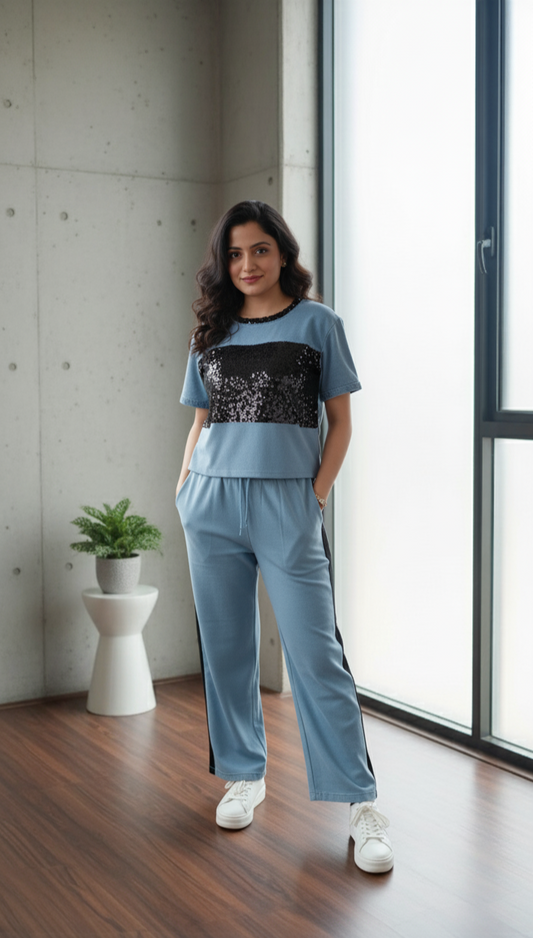 Woman wearing denim co-ord set with short-sleeve top and relaxed-fit drawstring pants styled with white sneakers.