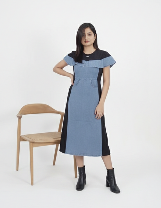 Woman wearing denim panelled midi dress in blue and black with short sleeves and round neck.