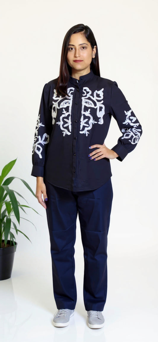 Woman wearing a dark blue outfit with white patterns on a white background
