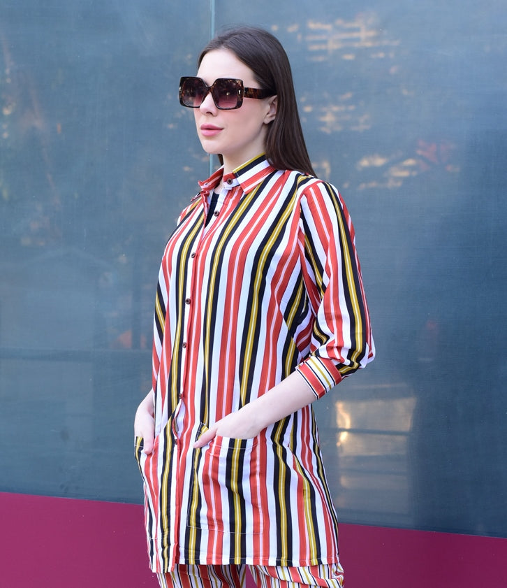 Woman wearing a colorful striped shirt against a reflective surface, stylish and versatile co-ord set for women.