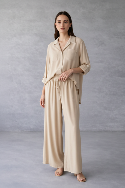 Woman wearing a beige outfit against a gray background