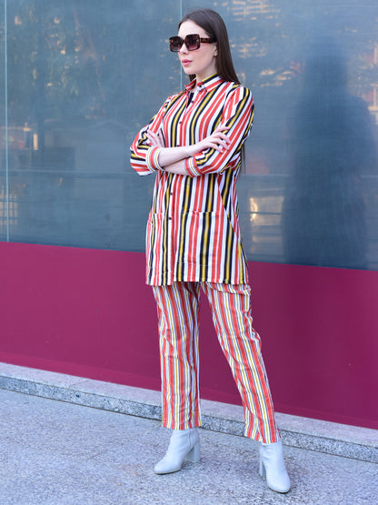 Woman wearing a colorful striped outfit standing against a reflective glass wall, stylish and versatile co-ord set for women 