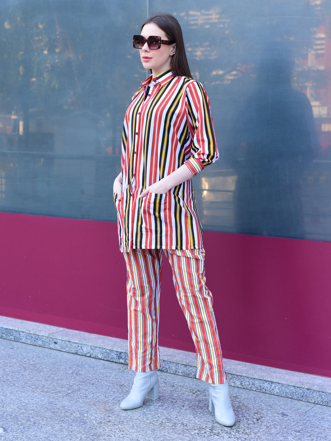 Woman in a colorful striped outfit standing against a reflective surface, stylish and versatile co-ord set for women 